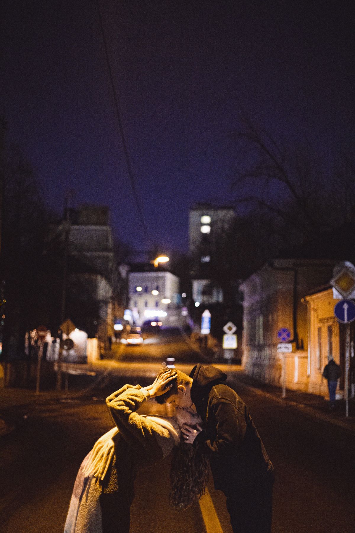 Stock stand-in: a couple on a city street at night under streetlights