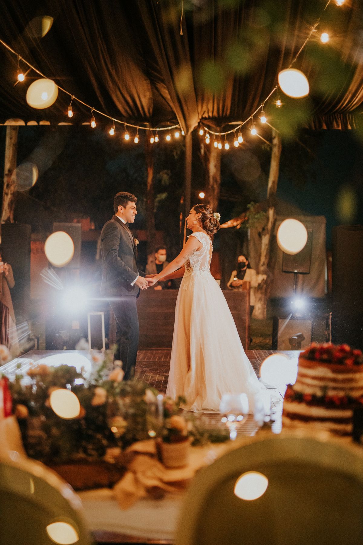 Stock stand-in: a couple's first dance with warm lights glowing behind them